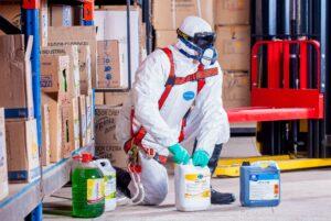 worker disposing chemicals with safety equipment