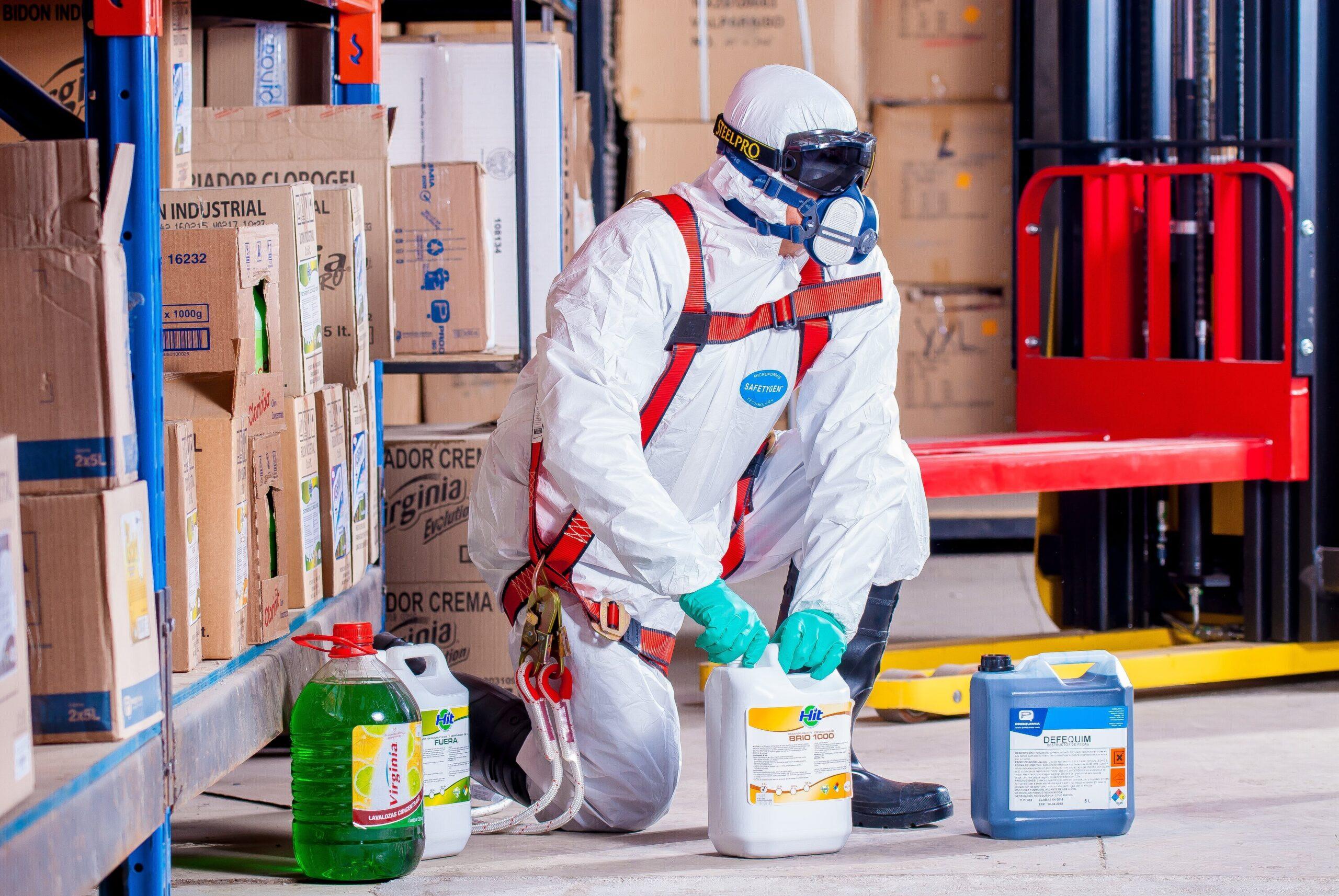 worker disposing chemicals with safety equipment
