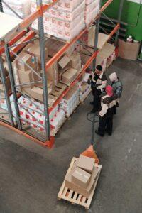 3 people talking in a warehouse view from above